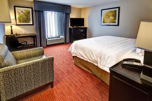 ein Hotelzimmer mit einem Bett, einem Schreibtisch und einem Stuhl in der Unterkunft Hampton Inn and Suites Ada in Ada