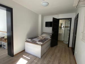 a small bedroom with a bed and a mirror at Penzion U Adama in Karlštejn