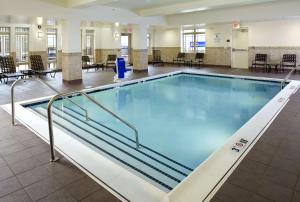 a large swimming pool in a building with tables and chairs at Hilton Garden Inn Roanoke in Roanoke