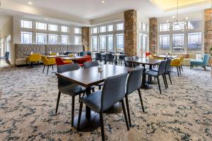 a dining room with tables and chairs and windows at Hilton Garden Inn Roanoke in Roanoke