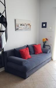 a blue couch with red pillows in a room at Harmony by the sea - 20 meters from the sea in Kaloi Limenes
