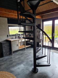 a spiral staircase in the middle of a kitchen at B&B Bos en Wei XL in Hall