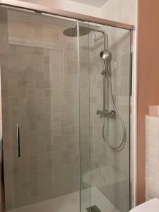 a shower with a glass door in a bathroom at Studio d'architecte à 150 m de la plage in Royan