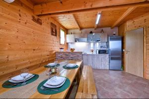 una cocina con paredes de madera y una mesa con platos y copas de vino en Ruralna kuća za odmor RAJSKI MIR en Tuhelj