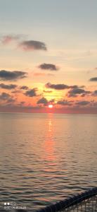 a sunset over the water with the sun setting at Villa Rosati B & B - Home Restaurant in Capoterra