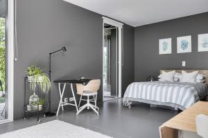 a bedroom with a bed and a table and a desk at Style Meets Location in Göteborg in Gothenburg