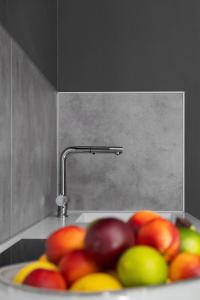 a bowl of fruit in a sink with a faucet at Style Meets Location in Göteborg in Gothenburg