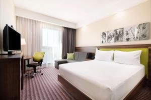 a hotel room with a large bed and a television at Hampton by Hilton Krakow in Krakow