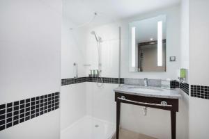 a bathroom with a sink and a shower and a mirror at Hampton by Hilton Krakow in Krakow +25 photos