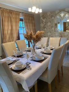 a dining room table with a white table cloth and chairs at Alnside Lodge near Alnmouth with hot tub in Lesbury