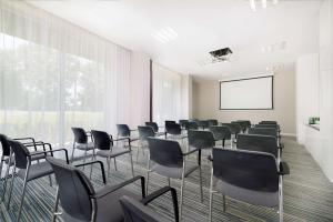 une salle de conférence avec des chaises et un écran de projection dans l'établissement Hampton by Hilton Krakow, à Cracovie