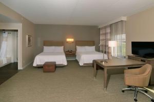 a hotel room with two beds and a desk and a television at Hampton Inn Springfield-Southeast, MO in Springfield +20 photos