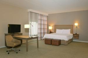 1 dormitorio con 1 cama y escritorio con TV en Hampton Inn Springfield-Southeast, MO en Springfield