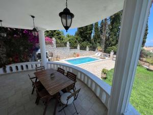 a patio with a table and chairs and a pool at Casa StaLa in Kastanéa +20 photos