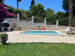 a swimming pool in a yard next to a stone wall at Casa StaLa in Kastanéa