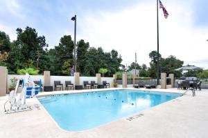 einen Pool in einem Hotel mit Stühlen und einer Flagge in der Unterkunft Hampton Inn Macon - I-475 in Macon