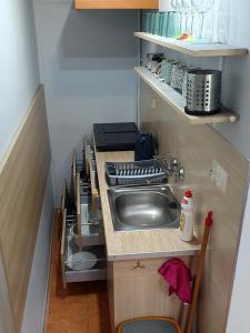 a small kitchen with a sink and a stove at Pokoje Gościnne Mączyński in Polanica-Zdrój
