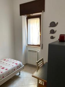 a bedroom with a bed and a chair and a window at Casangiù in Crispiano