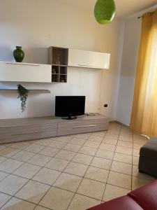 uma sala de estar com uma televisão num piso de azulejo em Casangiù em Crispiano