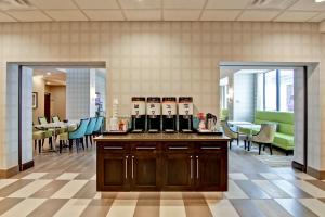 a lobby with a counter with bottles of wine on it at Hampton Inn & Suites by Hilton Saskatoon Airport in Saskatoon