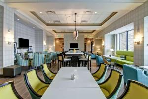 a waiting room with tables and chairs in a hospital at Hampton Inn & Suites by Hilton Saskatoon Airport in Saskatoon