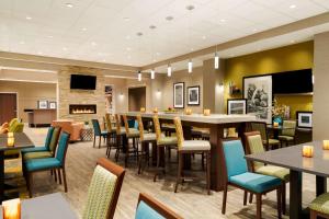 a restaurant with tables and chairs and a fireplace at Hampton Inn by Hilton Edmonton/Sherwood Park in Sherwood Park