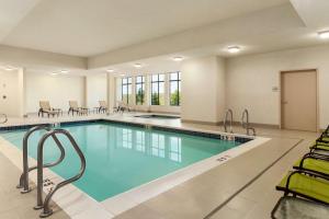 a pool in a hotel room with chairs and tables at Hampton Inn by Hilton Edmonton/Sherwood Park in Sherwood Park