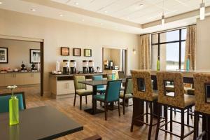 a dining room and kitchen with a table and chairs at Hampton Inn by Hilton Edmonton/Sherwood Park in Sherwood Park
