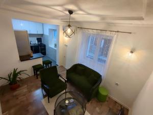 a living room with a green chair and a kitchen at Apartman ASKA in Višegrad