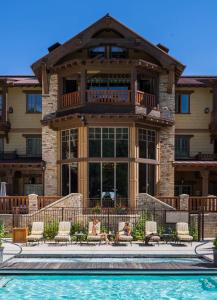 dos personas sentadas en sillas frente a una casa en Hotel Park City, Autograph Collection en Park City