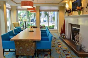 una sala da pranzo con un lungo tavolo e sedie blu di Hilton Garden Inn Daytona Beach Oceanfront a Daytona Beach