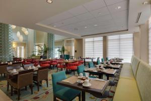 um restaurante com mesas e cadeiras num quarto em Hilton Garden Inn Daytona Beach Oceanfront em Daytona Beach