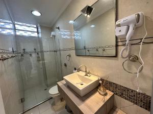 a bathroom with a shower toilet and a sink at Frente Mar! 3 quartos e 2 vagas in Santos