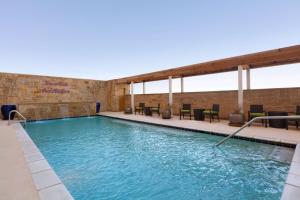 a pool in a building with chairs and tables at Home2 Suites by Hilton Lubbock in Lubbock