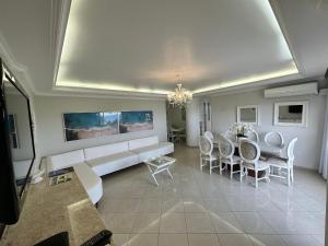 a living room with a couch and a table and chairs at Frente Mar! 3 quartos e 2 vagas in Santos