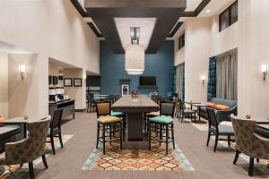 a lobby with tables and chairs and a dining area at Hampton Inn & Suites West Des Moines Mill Civic in West Des Moines