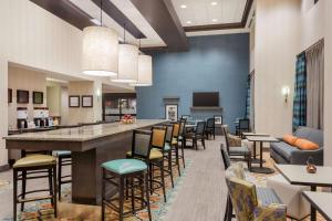a large lobby with a bar and chairs at Hampton Inn & Suites West Des Moines Mill Civic in West Des Moines