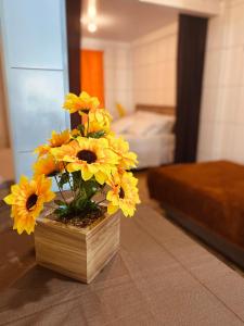 un jarrón lleno de flores amarillas sentadas en una mesa en Residenciais Maria Flor, en Gramado