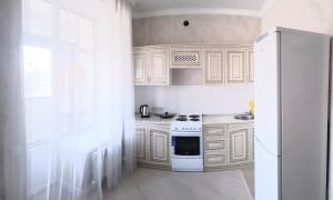uma cozinha com um fogão branco e um frigorífico em Квартира в центре левого берега Астаны Туран, 46А em Taldykolʼ