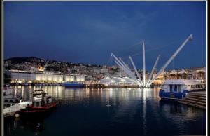 un port avec des bateaux dans l'eau la nuit dans l'établissement I Portici, à Gênes