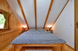 a large bed in a room with wooden walls at Ruralna kuća za odmor RAJSKI MIR in Tuhelj