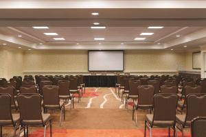 uma sala de conferências com cadeiras e um ecrã em Hilton Garden Inn Wallingford/Meriden em Wallingford