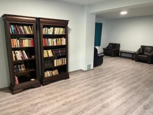 a living room with two book shelves filled with books at VILA SARA in Vârtopu