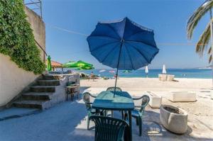 a table and chairs with an umbrella on the beach at Apartman Zrinka in Jesenice