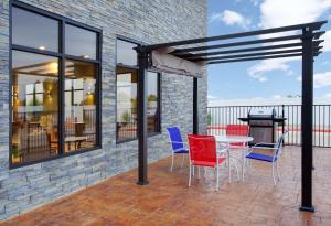 een patio met een tafel en stoelen en een grill bij Hampton Inn and Suites Snyder in Snyder
