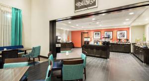 a waiting room with tables and chairs and a restaurant at Hampton Inn & Suites Orlando near SeaWorld in Orlando