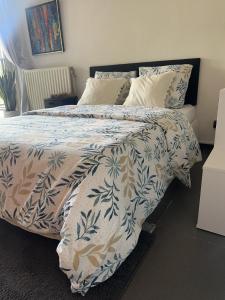 un letto con piumino e cuscini blu e bianchi di Studio Charmant&calme a Knokke-Heist