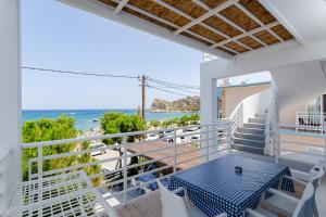a balcony with a table and a view of the ocean at George Apartments Stegna in Archangelos