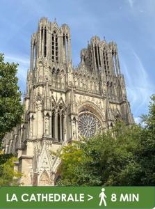 Una gran catedral con un reloj en la parte delantera. en Le Forum - HYPER centre - PARKING, en Reims