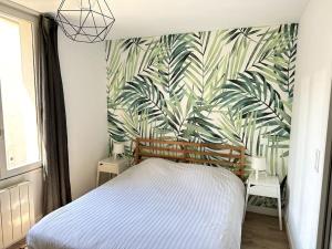 1 dormitorio con 1 cama con papel pintado tropical en Le Forum - HYPER centre - PARKING, en Reims